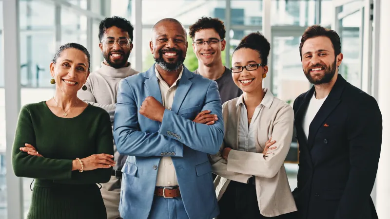 6 people clad in business attire standing together and smiling at the viewer