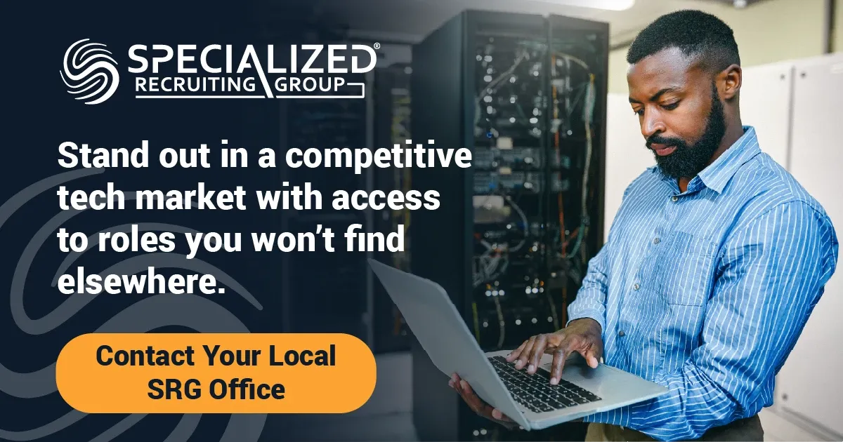 Photo advertisement showing a person with a beard wearing a blue striped button-down shirt using a laptop in a server room. Logo and text: “SPECIALIZED RECRUITING GROUP” and “Stand out in a competitive tech market with access to roles you won’t find elsewhere.” Button text: “Contact Your Local SRG Office”.