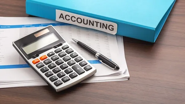 Calculator, financial report, and certification folder on a wooden office desk representing accounting certifications, professional development, and career advancement in the finance and accounting field.