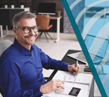 Male accountant working on calculator and laptop at desk