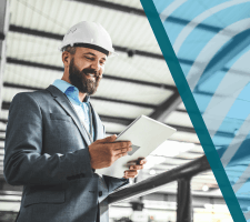 Engineer in suit and hard hat reviewing plans