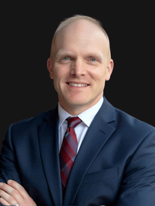 Professional photo of Adam, director of recruiting and professional staffing. He is a middle aged man with dark hair. He is dressed in business professional clothes. 