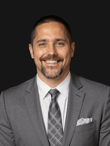 Professional portrait of Jacob dressed in business professional attire and smiling.